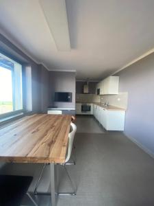a large kitchen with a wooden table in a room at Hullám Panorama & Jacuzzi in Balatonlelle