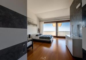 salon z łóżkiem i dużym oknem w obiekcie LANGA SUNSET VILLA w mieście Belvedere Langhe