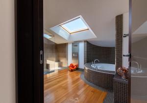 a bathroom with a large tub and a skylight at Villa in Langa in Belvedere Langhe +71 photos