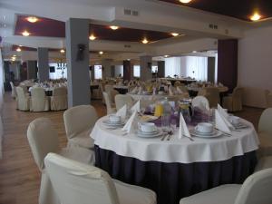 a banquet hall with white tables and chairs at Hotel Akor in Bydgoszcz