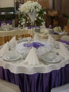 une table avec des assiettes et des fleurs blanches dans l'établissement Hotel Akor, à Bydgoszcz