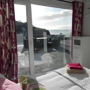 a room with a large window with a view of the ocean at Bay View, Millendreth Looe Cornwall in Looe