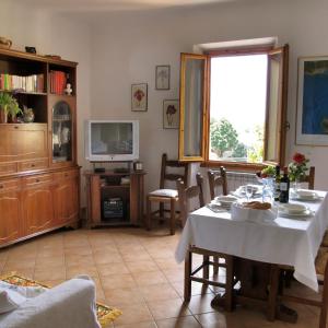 a living room with a table and a tv at Casa Martellina - Holiday Home in Bagno a Ripoli