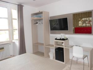 ローマにあるB&B Domus Chiaraのベッドルーム(デスク、テレビ、椅子付)