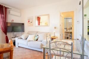 - un salon avec un canapé blanc et une télévision dans l'établissement Suites La Marina de Isla Canela, à Isla Canela