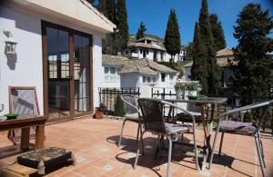 een patio met stoelen en een tafel en een huis bij Casa Guidai in Granada