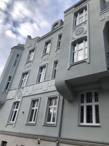 a gray building with white windows on the side of it at Apartament w Bydgoszczy, dzielnica muzyczna in Bydgoszcz