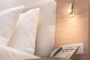 um quarto com uma cama com controlo remoto em Holiday Inn Express - Erlangen, an IHG Hotel em Erlangen