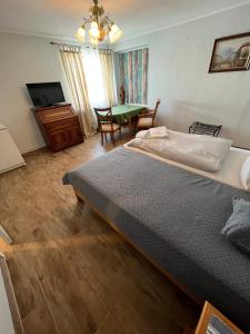 1 dormitorio con cama, mesa y TV en Gästehaus Geli, en Heide