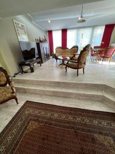 a living room with chairs and a table and a piano at Gästehaus Geli in Heide