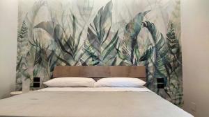 1 dormitorio con 1 cama con un mural de plantas en 3B Aurora - Bed Breakfast and Boat, en Salerno