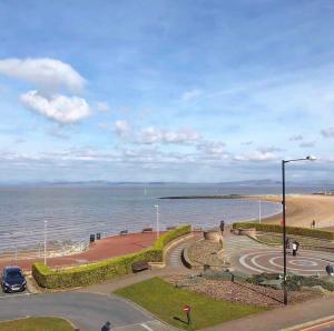 a road next to the ocean with a street light at Lovely 2 bedroom modern loft apartment sea view in Morecambe