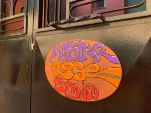 a sign on the side of a building with graffiti at MASTER ROSE STUDIO in old town in Nafplio