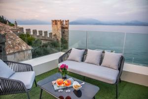 a balcony with a couch and a table with food on it at Hotel Degli Oleandri in Sirmione