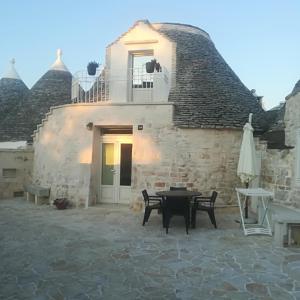 a house with a thatched roof and a patio at Trulli Manuela 2 in Locorotondo