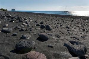 un grupo de rocas en una playa cerca del agua en Via Marina, en Stromboli