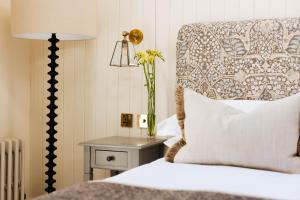 a bedroom with a bed and a table with a lamp at The Yard in Bath Hotel in Bath