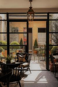 a patio with chairs and a table and windows at The Yard in Bath Hotel in Bath