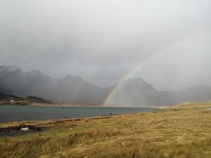 um arco-íris sobre uma massa de água com montanhas ao fundo em Torrin Bunkhouse em Torrin