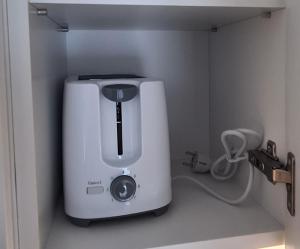a small white appliance in a corner of a room at 61 - Apartamenty Siedlce - Nowy apartament w centrum przy ul 3 Maja 51a in Siedlce