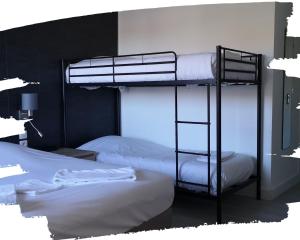 a bedroom with two bunk beds with white sheets at Hotel du Cheval Blanc in Cerizay