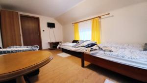 ポラニツァ・ズドルイにあるAgroturystyka u Joliのベッド2台、テーブル、窓が備わる客室です。