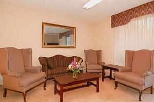 a waiting room with chairs and a table and a mirror at OYO Hotel Doswell Kings Dominion in Doswell