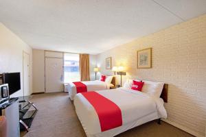 Cette chambre comprend deux lits et une télévision. dans l'établissement OYO Hotel Doswell Kings Dominion, à Doswell