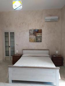 1 dormitorio con 1 cama blanca y 2 mesitas de noche en Enjoy Etna, en Zafferana Etnea