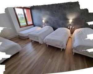 a room with four beds and a wooden floor at Hotel du Cheval Blanc in Cerizay +12 photos
