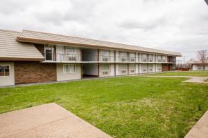 a building with a green lawn in front of it at OYO Hotel Lebanon MO I-44 in Lebanon