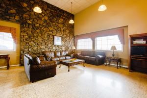 a living room with leather couches and a stone wall at OYO Hotel Lebanon MO I-44 in Lebanon