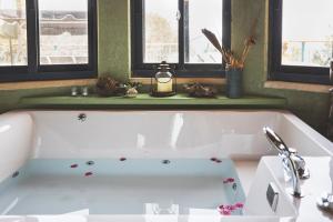 uma banheira branca na casa de banho com janelas em קטלב kta-love em Kammon