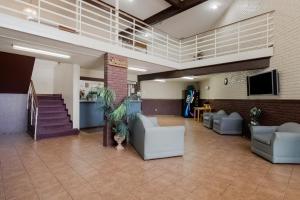 a lobby with couches and a tv and a staircase at OYO Hotel Morton East Peoria I-74 in Morton