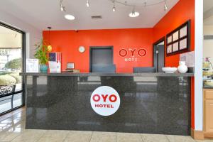 a hotel lobby with an orange wall at OYO Hotel Twin Lake- Lake Park Valdosta area in Lake Park