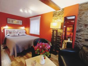 a bedroom with a bed and a table with flowers on it at Apartamentos La Casa del Pintor in Cudillero +8 photos