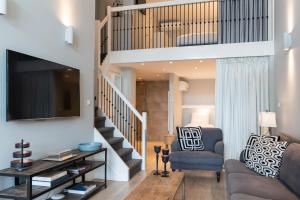 een woonkamer met een trap en een bank bij Park Central Apartments in Den Haag