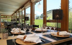 una mesa con copas de vino y servilletas. en Hôtel Restaurant La Buffe, en Autrans