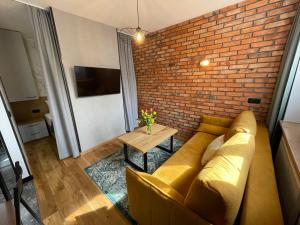 a living room with a couch and a brick wall at RAJSKA BRAMA in Gdańsk