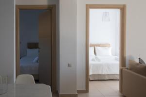 a room with a bedroom with a bed and a mirror at Niovi Boutique Apartments in Afitos