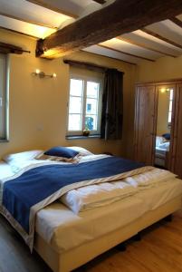 a bedroom with a large bed with a blue blanket at Vakantiewoningen-Pizzeria Blanckthys Voeren in Voeren