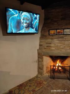 a television hanging on a wall above a fireplace at Mozitas 33 in Barra del Chuy