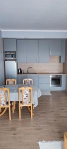 uma cozinha com uma mesa e cadeiras numa cozinha em Apartament Północna em Brodnica