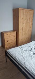 een slaapkamer met een bed en een dressoir bij Apartament Północna in Brodnica