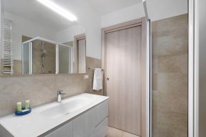 bagno con lavandino bianco e doccia di Appartamento Shanaia a Loano