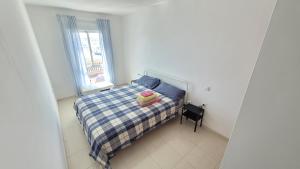 mała sypialnia z łóżkiem i oknem w obiekcie Amazing ocean view apartment w Corralejo