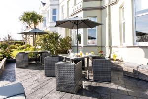 a patio with a table and chairs with an umbrella at Shelleven Guest House in Bangor