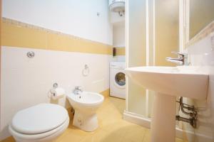 a bathroom with a toilet and a sink and a washing machine at Casa sul molo in Cefalù +11 photos