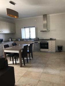 eine Küche mit einem Holztisch und Stühlen in einem Zimmer in der Unterkunft Moradia Gémea em Herdade Santa Marta in Zebreira