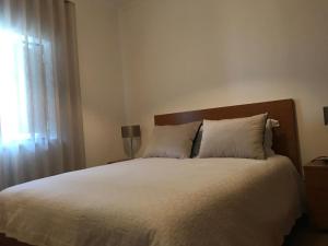 ein Schlafzimmer mit einem großen weißen Bett mit einem Fenster in der Unterkunft Moradia Gémea em Herdade Santa Marta in Zebreira + 4 Fotos